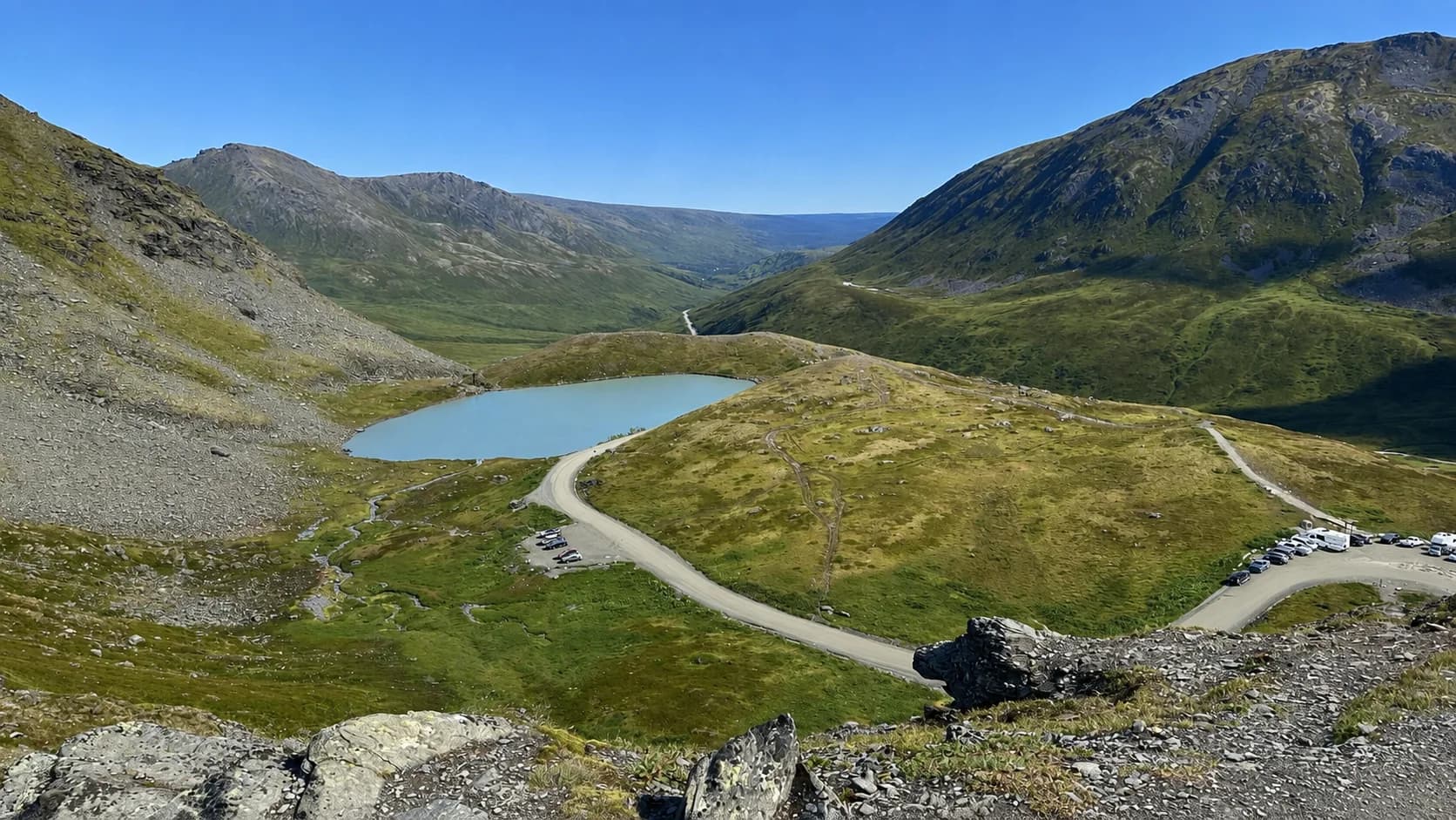 Summit Lake at Hatcher Pass, an alpine tarn beside the road with mountains and the Willow Creek valley beyond