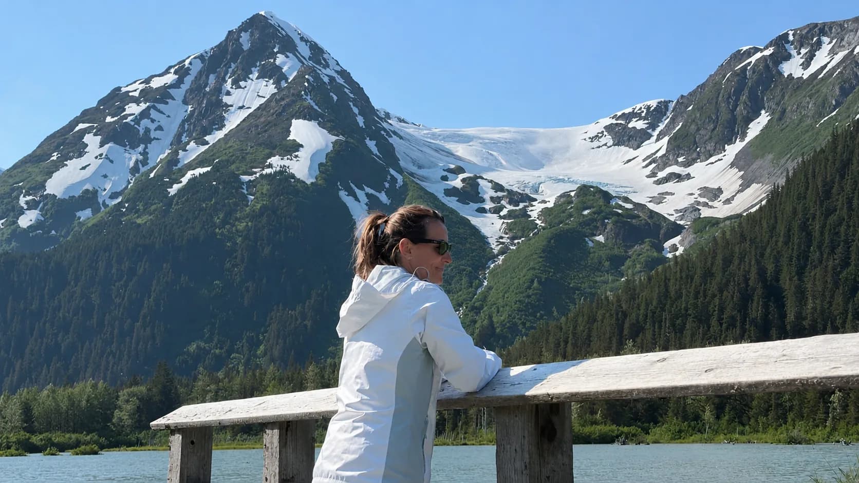 A hiker on the Portage Valley trail below the glacier and surrounding peaks